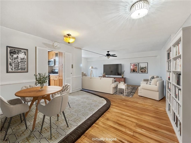 dining space with built in shelves, ceiling fan, and hardwood / wood-style flooring