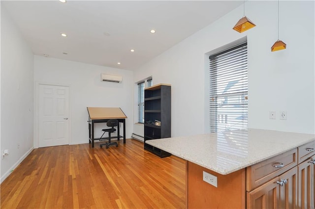 kitchen featuring an AC wall unit, hanging light fixtures, baseboard heating, light stone countertops, and light hardwood / wood-style flooring