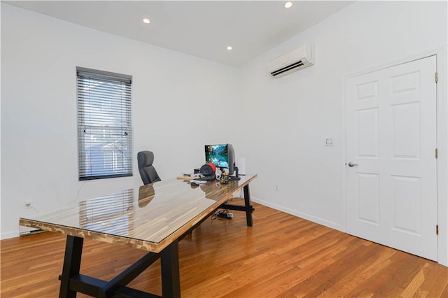 home office with a wall mounted air conditioner and light hardwood / wood-style flooring