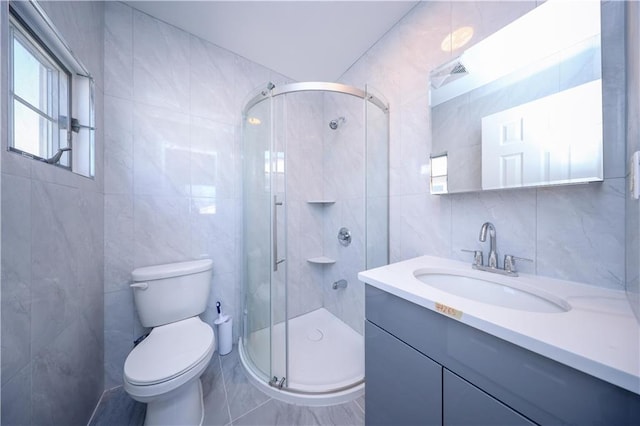 bathroom featuring vanity, tile walls, an enclosed shower, and toilet