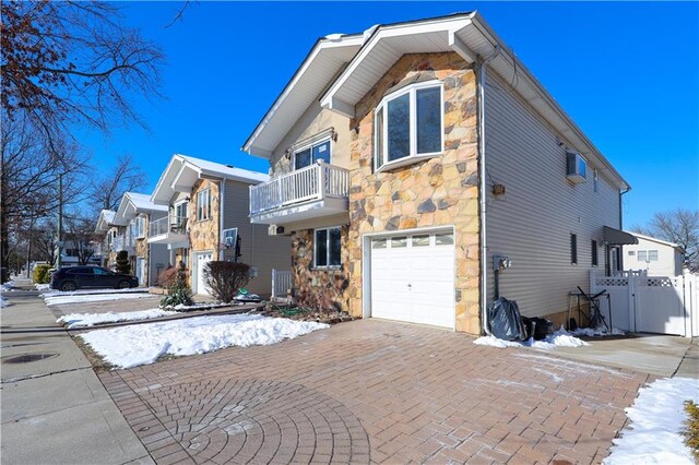 view of front of property featuring a garage and a balcony