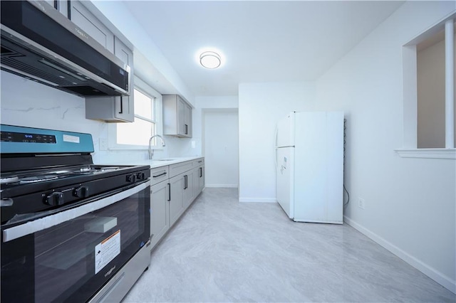 kitchen featuring ventilation hood, sink, gray cabinetry, white fridge, and gas stove