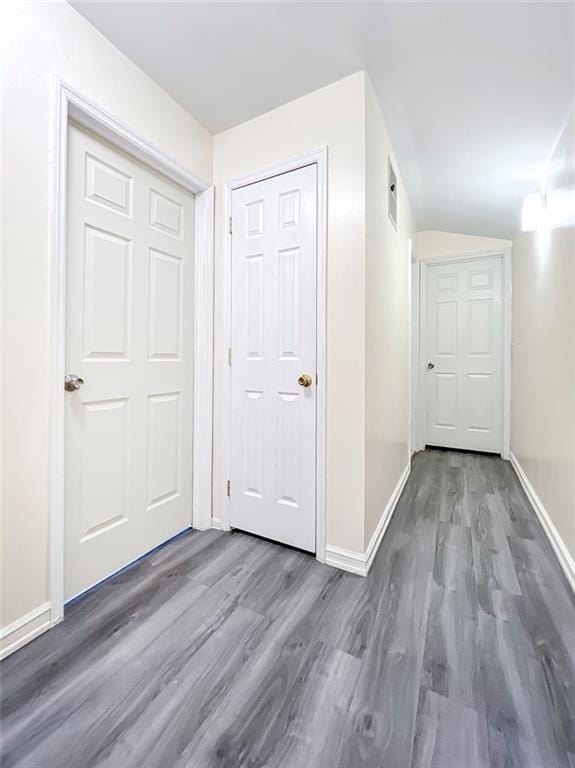 hall featuring baseboards and wood finished floors