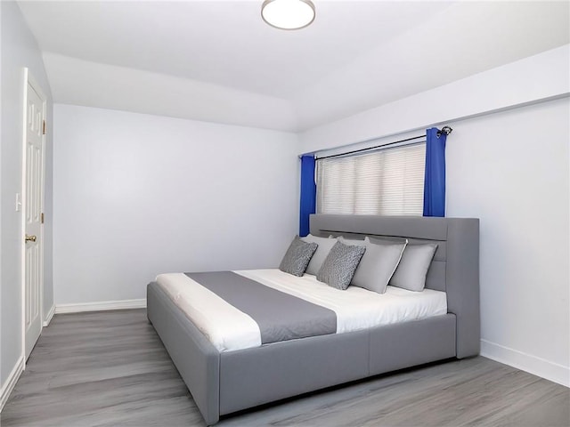 bedroom with wood finished floors and baseboards