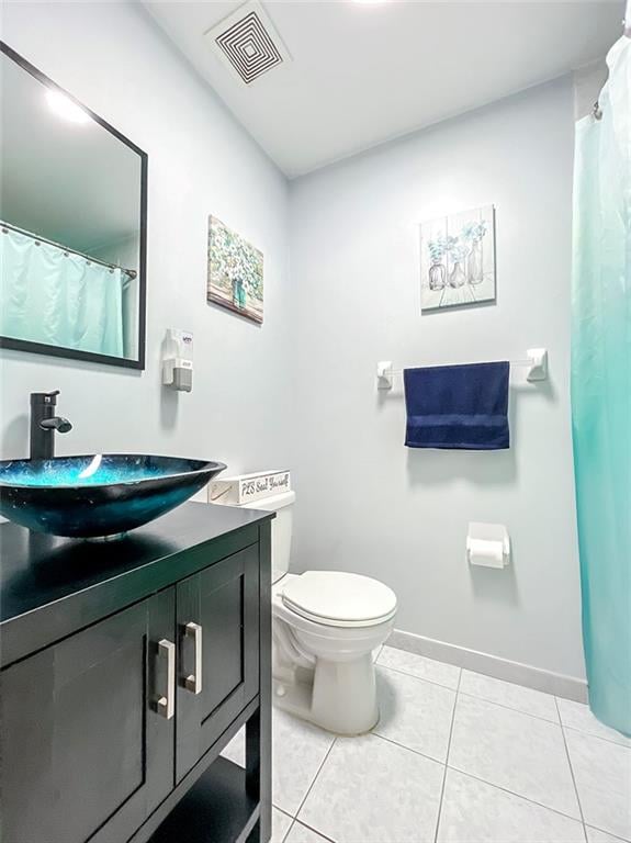 full bathroom featuring toilet, vanity, baseboards, visible vents, and tile patterned floors