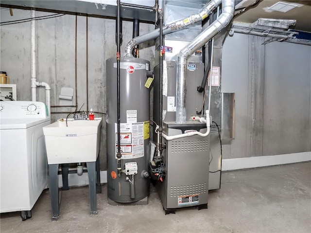 utility room with heating unit, a sink, washer / clothes dryer, and gas water heater