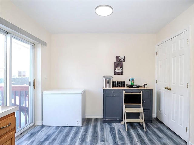 bar with baseboards, dark wood finished floors, and white fridge