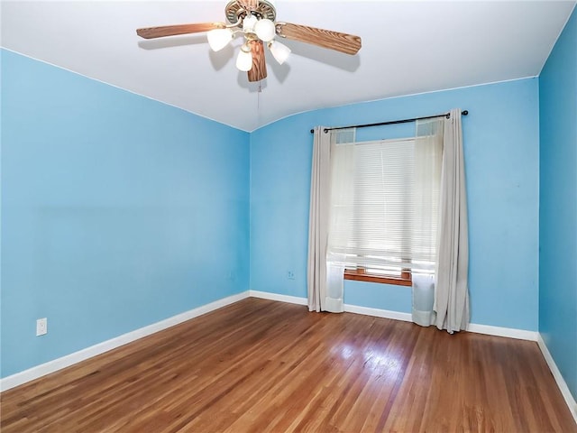 unfurnished room featuring baseboards, a ceiling fan, and wood finished floors