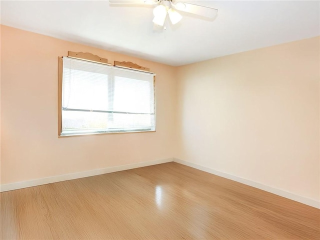 unfurnished room featuring baseboards, a ceiling fan, and light wood finished floors