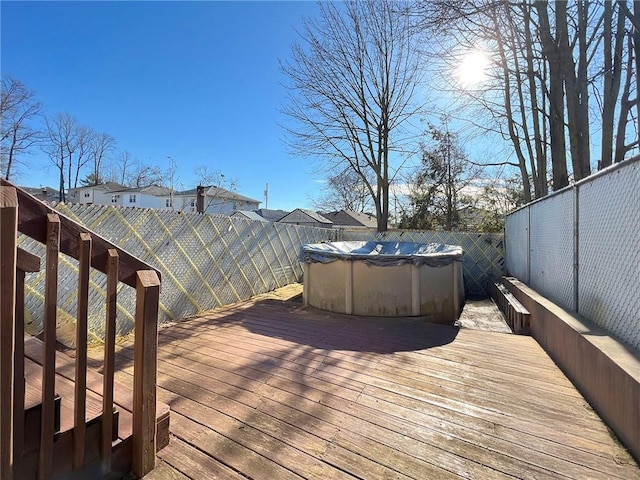wooden terrace with a fenced in pool and a fenced backyard