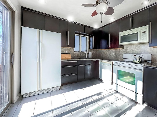 kitchen with white appliances, light tile patterned flooring, ceiling fan, and decorative backsplash