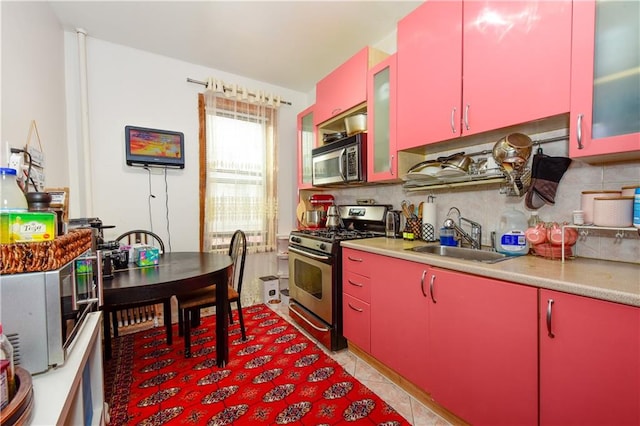 kitchen with stainless steel appliances, sink, light tile patterned floors, and backsplash