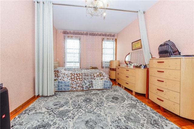 bedroom with hardwood / wood-style flooring and a notable chandelier