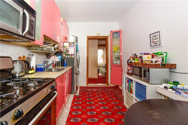 kitchen featuring light tile patterned floors, backsplash, stainless steel appliances, and sink