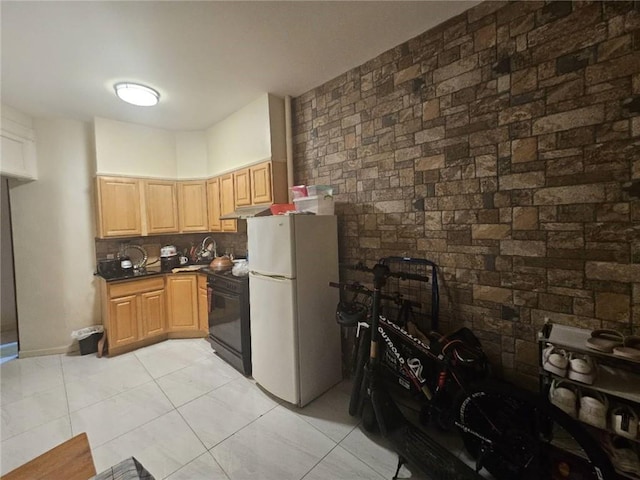 kitchen with under cabinet range hood, black gas stove, freestanding refrigerator, tasteful backsplash, and dark countertops