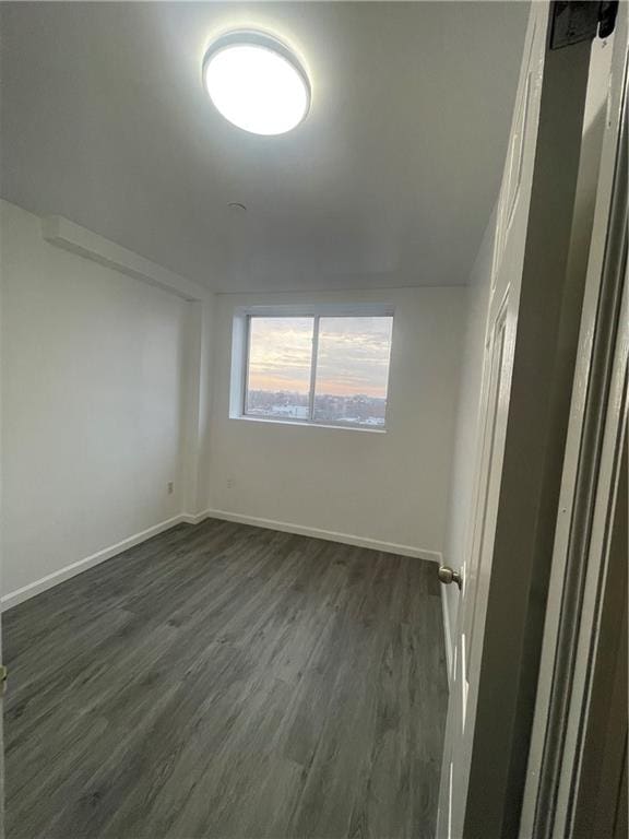 unfurnished room with dark hardwood / wood-style flooring