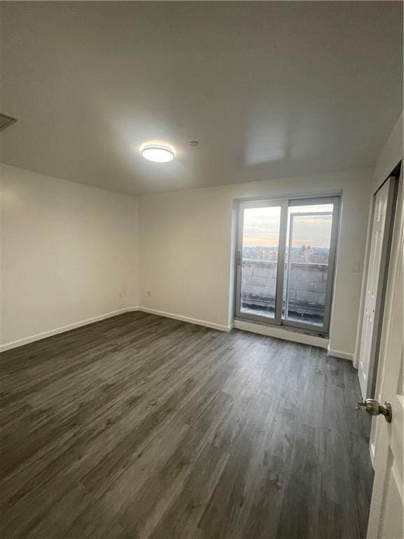 spare room with dark wood-type flooring