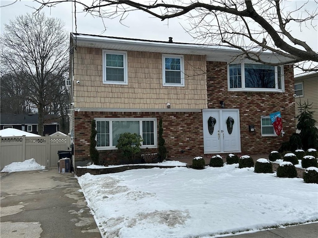 view of front of home featuring brick siding and fence