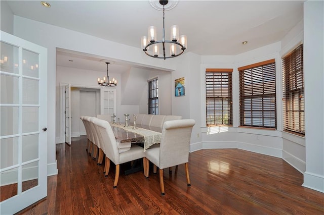 dining space featuring a notable chandelier, dark wood-style floors, and baseboards