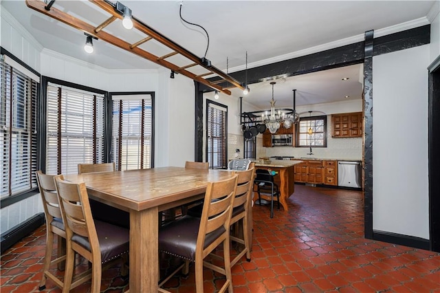 dining room with ornamental molding and a chandelier