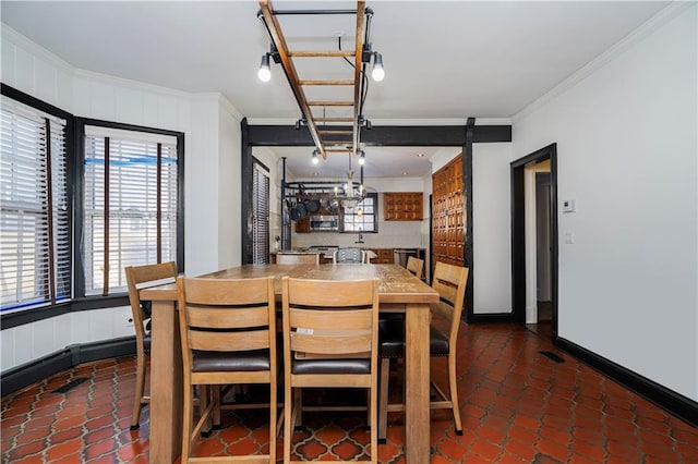 dining space with tile patterned flooring, crown molding, and baseboards