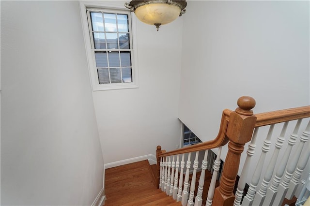 stairway featuring baseboards and wood finished floors