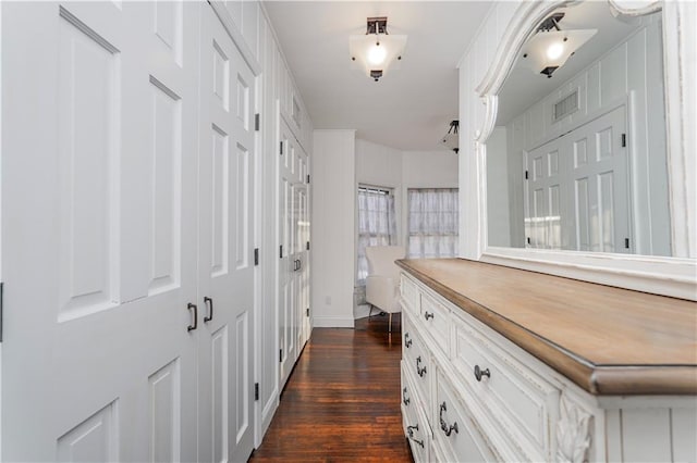 hallway featuring dark wood finished floors and visible vents