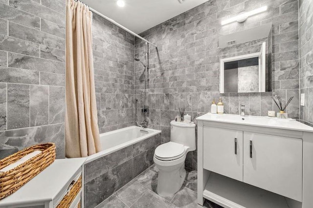 full bathroom with vanity, toilet, tile walls, and shower / bath combo