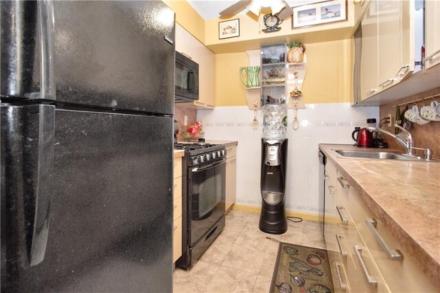 kitchen featuring light tile patterned flooring, tasteful backsplash, sink, ceiling fan, and black appliances