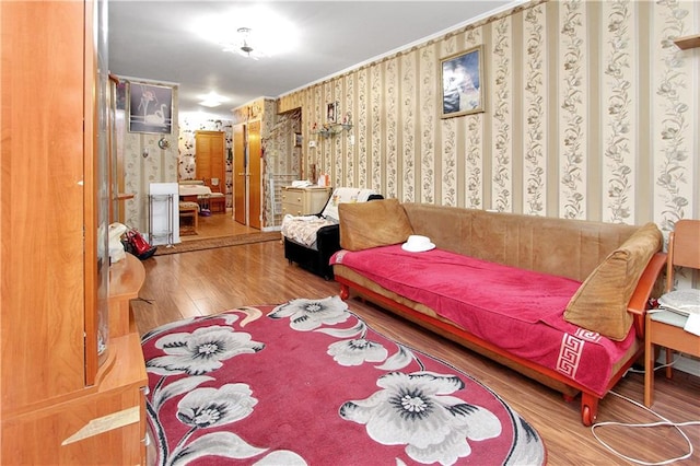 living area with wallpapered walls and wood finished floors