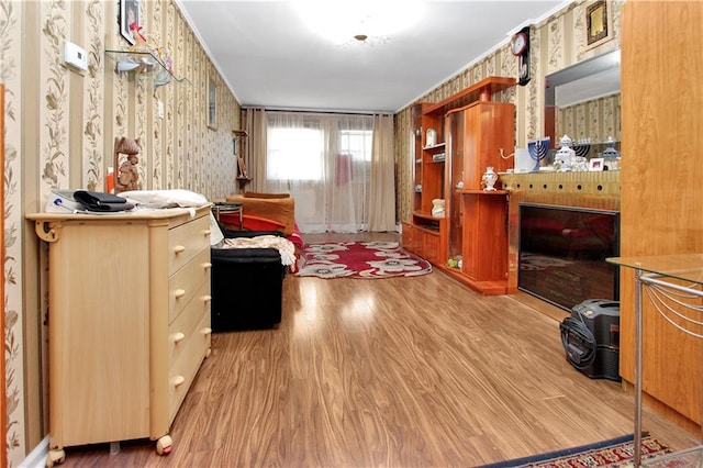 bedroom featuring wood finished floors and wallpapered walls