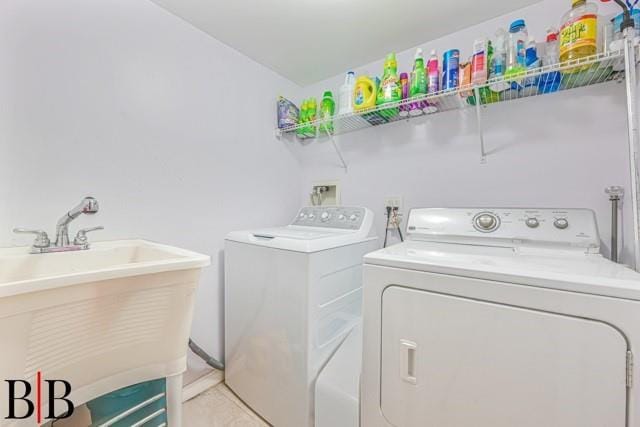 clothes washing area with separate washer and dryer and sink