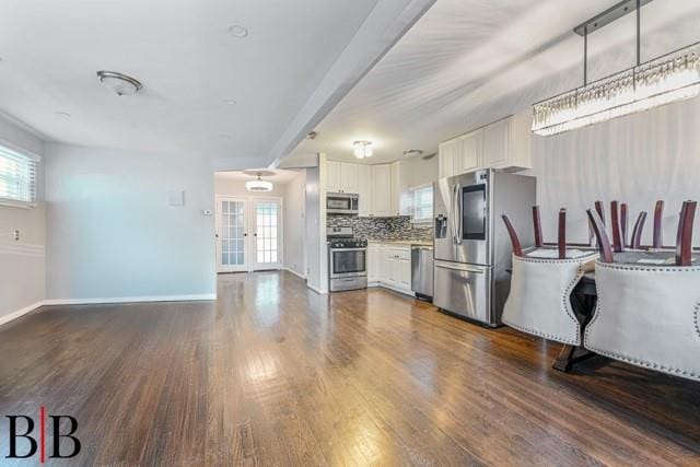 kitchen with white cabinetry, appliances with stainless steel finishes, dark wood-type flooring, and decorative backsplash