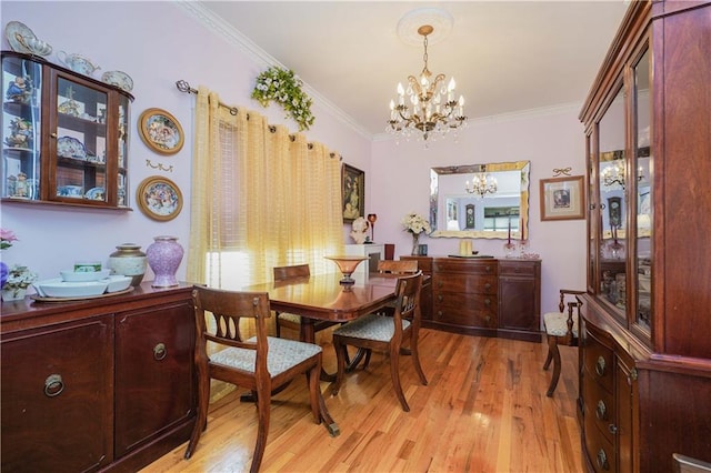 dining room featuring a chandelier, light wood-type flooring, and crown molding