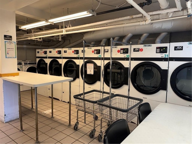 shared laundry area with tile patterned flooring and washing machine and dryer