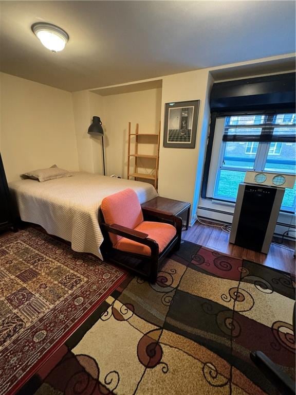 bedroom with hardwood / wood-style flooring and a baseboard radiator