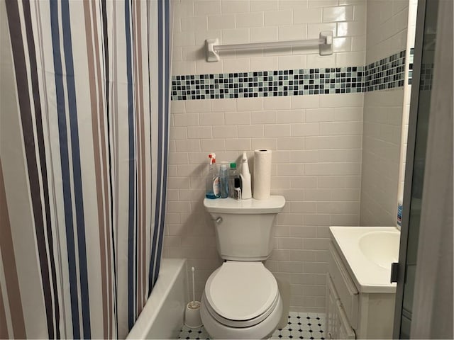 bathroom with shower / bath combo with shower curtain, toilet, tile walls, and vanity