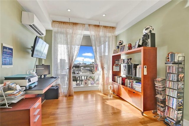 home office featuring a wall mounted air conditioner and hardwood / wood-style flooring