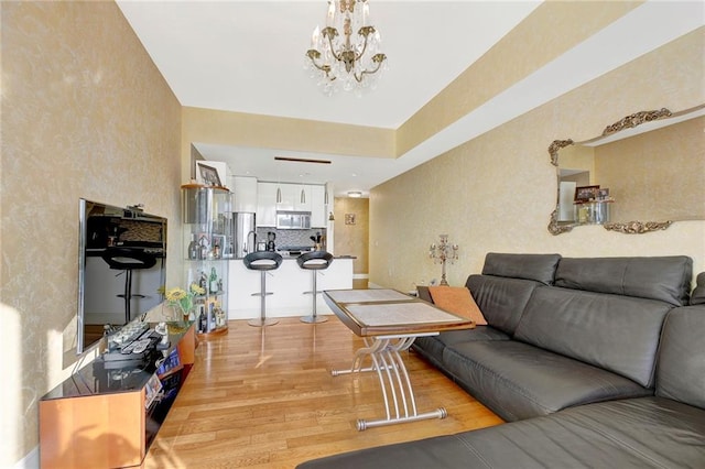 living room with a notable chandelier and light hardwood / wood-style floors