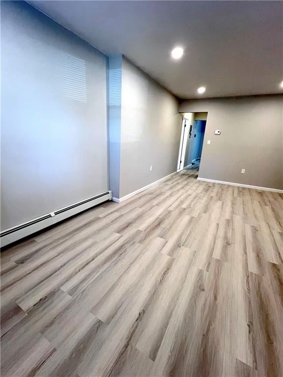 spare room with light wood-type flooring and baseboard heating