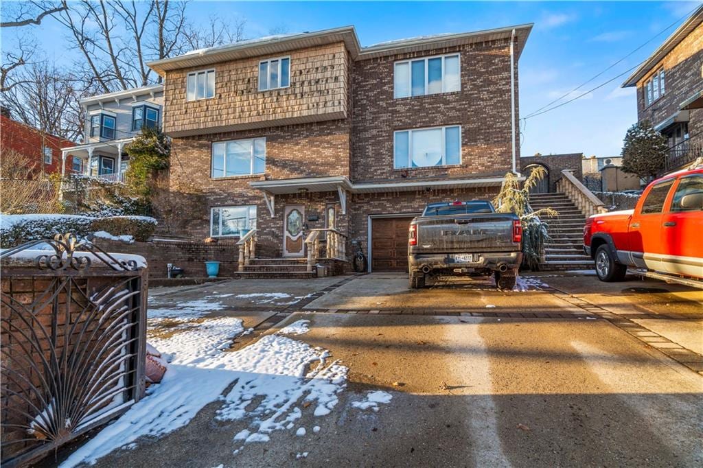 1281 Richmond Rd, Staten Island, NY 10304 - view of property featuring brick siding, driveway, and a garage
