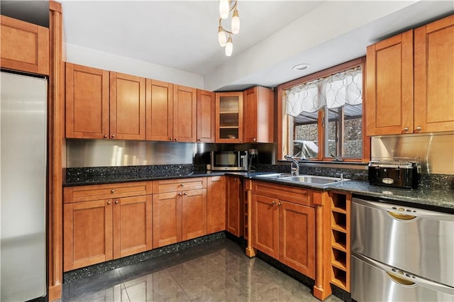 kitchen featuring stainless steel appliances, sink, and dark stone countertops