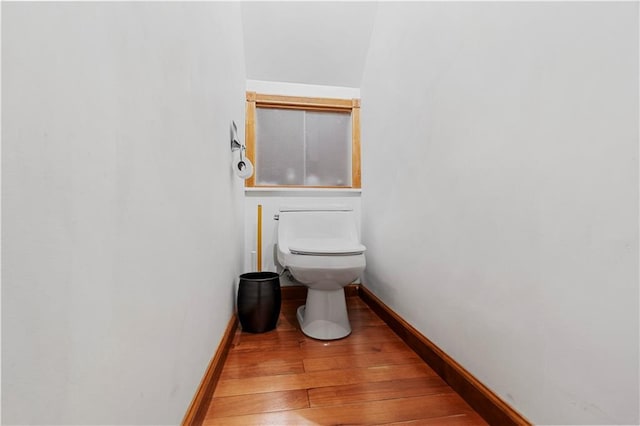 bathroom featuring wood-type flooring and toilet