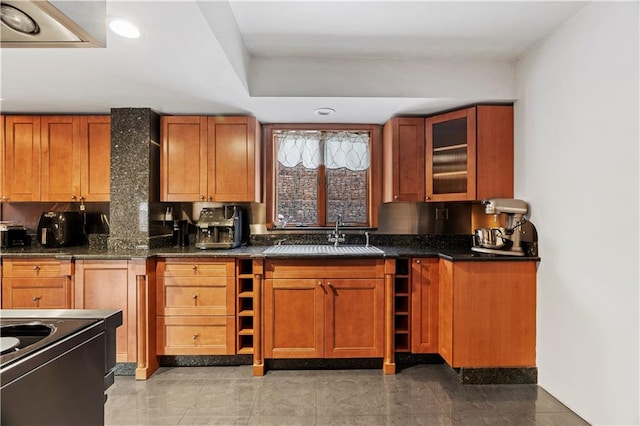 kitchen featuring tasteful backsplash, dark stone counters, and sink