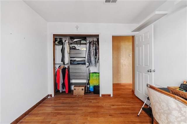 hallway with hardwood / wood-style floors