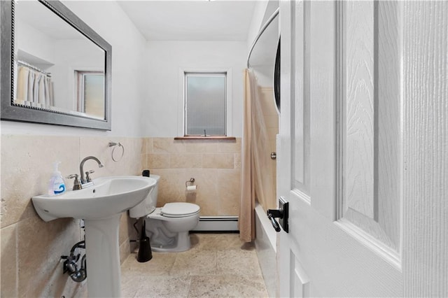 bathroom featuring a baseboard heating unit, tile walls, shower / tub combo, and toilet