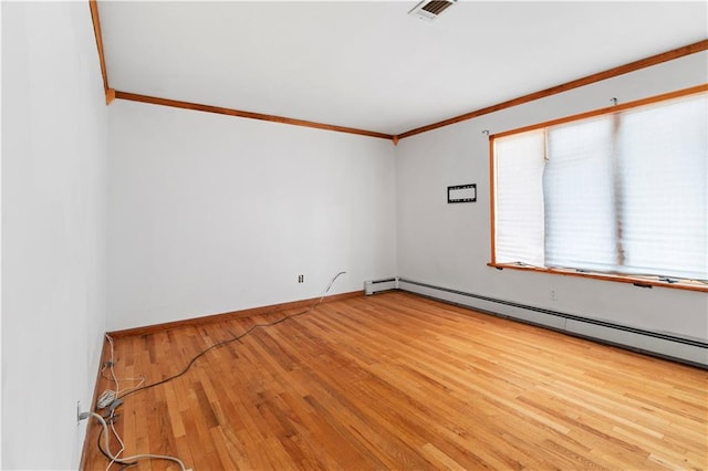 empty room with baseboard heating, crown molding, and hardwood / wood-style flooring