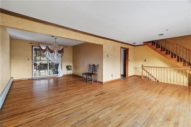 unfurnished living room with ornamental molding, a chandelier, and hardwood / wood-style floors