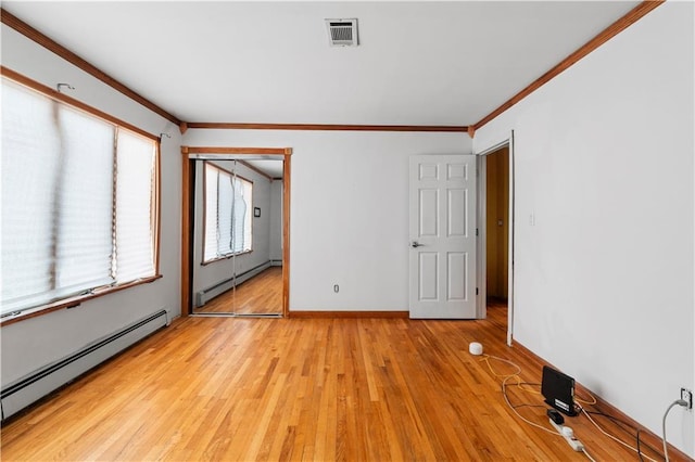 unfurnished room with ornamental molding, baseboard heating, and light hardwood / wood-style floors