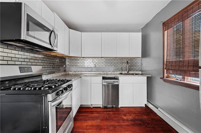 kitchen with a baseboard heating unit, sink, white cabinets, and appliances with stainless steel finishes